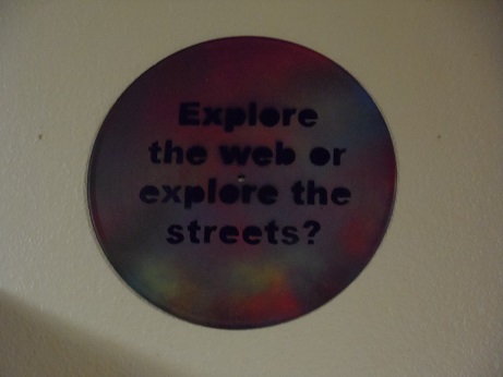 A sign saying: "Explore the web or explore the streets?"